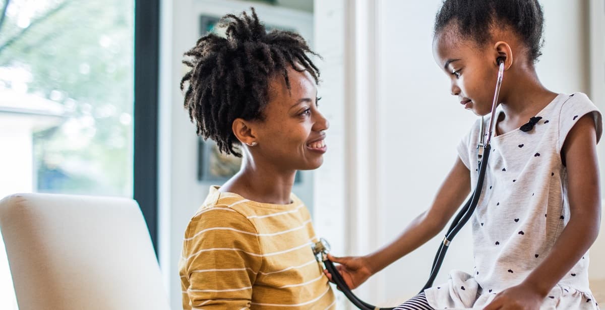 kindje luistert via de stethoscoop naar het hart van haar ouder