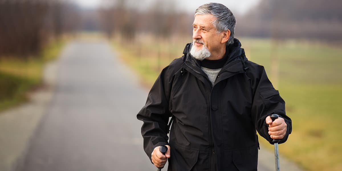 Man met wandelstokken in de natuur