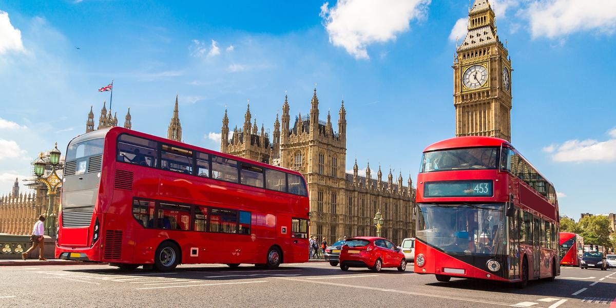Twee rode bussen in Londen bij het paleis van Westminster en de grote klok de Big Ben