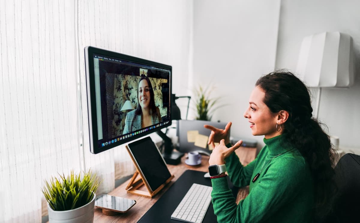Adviseur zit achter haar computer en heeft online een afspraak met een vrouw