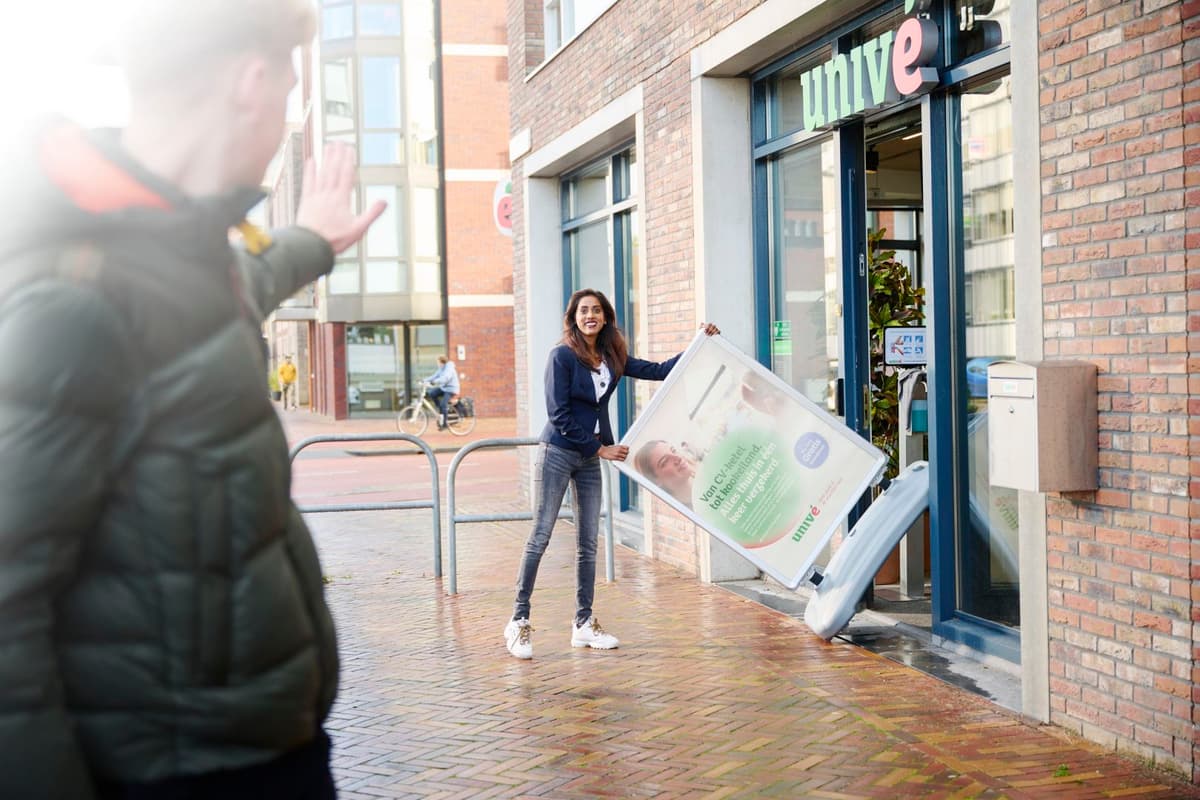 winkel medeweker haalt bord naar buiten