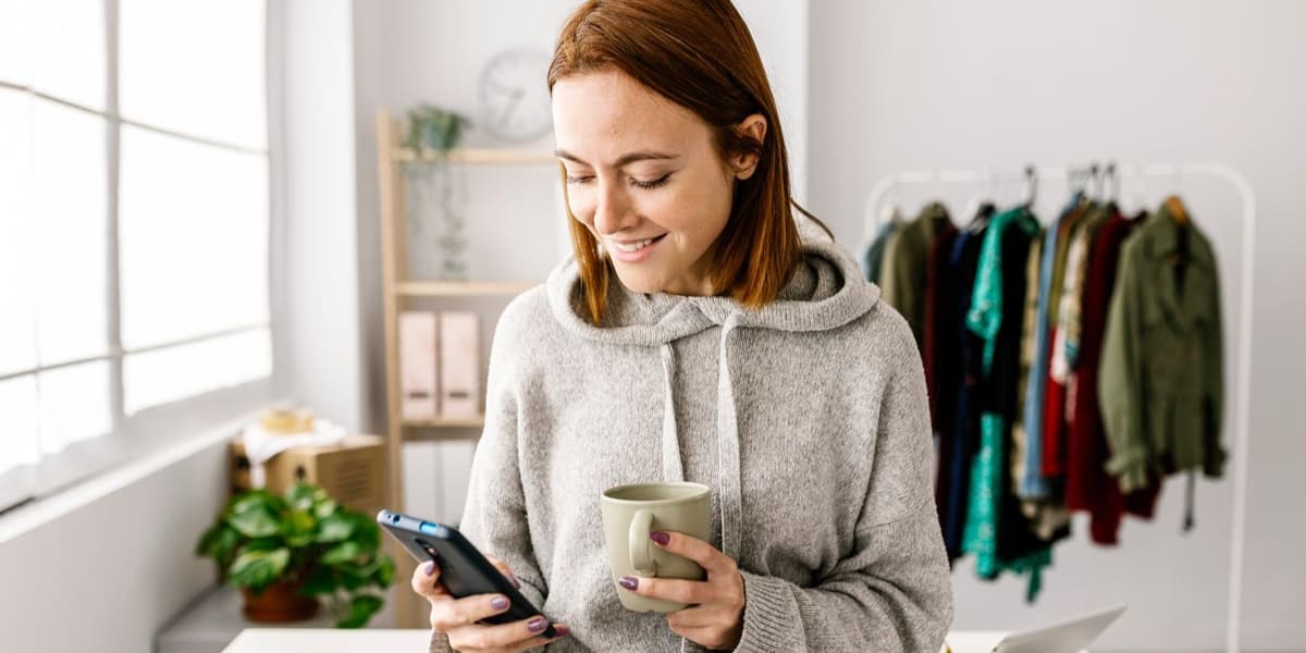 vrouw glimlachend met smartphone in haar hand