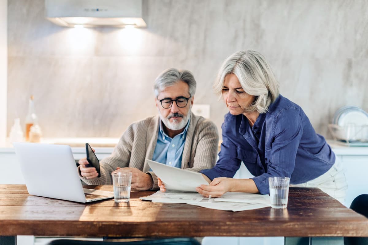 Ouder stel zit achter laptop en meldt schade online