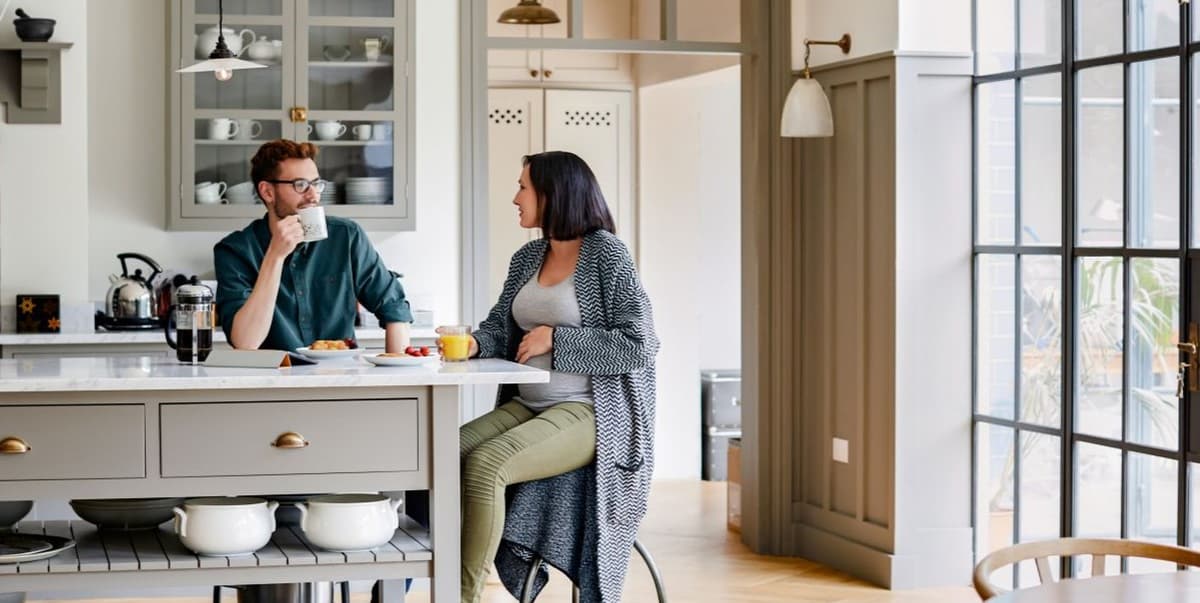 Stel aan keukentafel in gesprek met elkaar tijdens een kop koffie