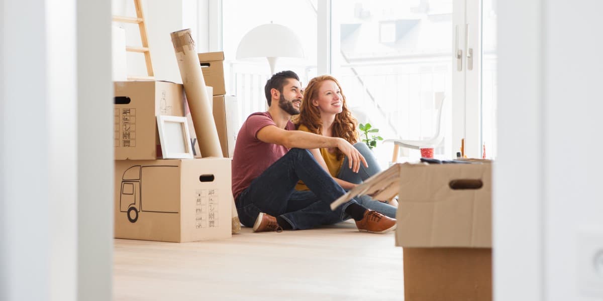 Stel met inboedel in verhuisdozen in hun nieuwe huurwoning
