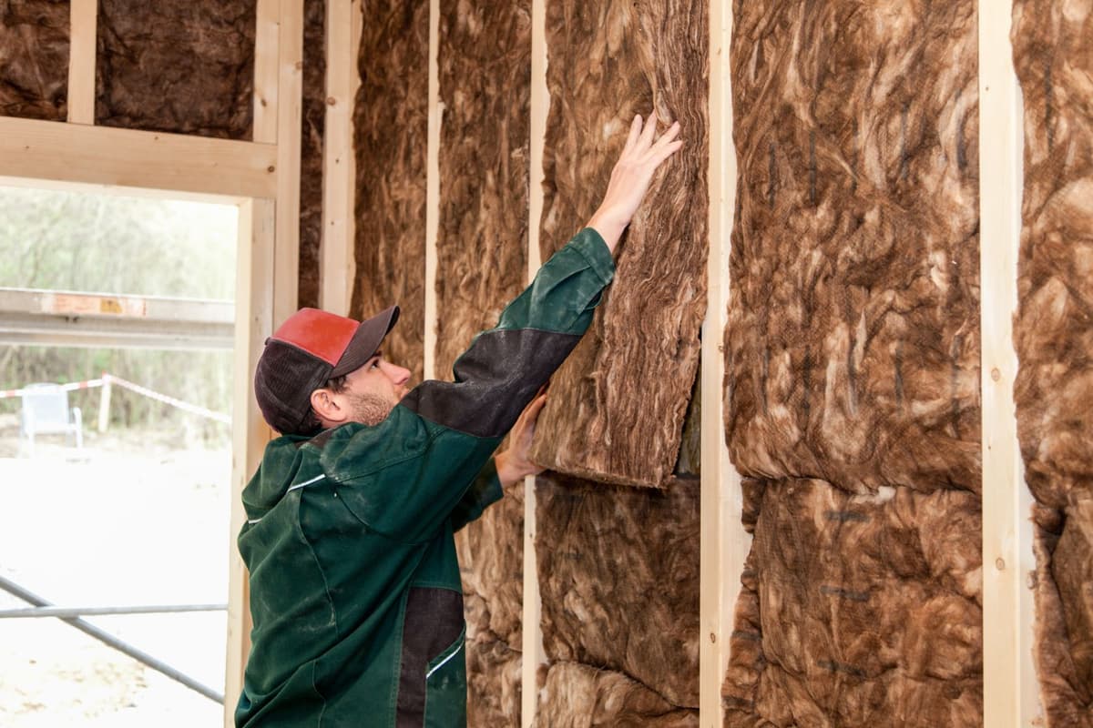 Man is in een huis een muur aan het isoleren met isolatiemateriaal