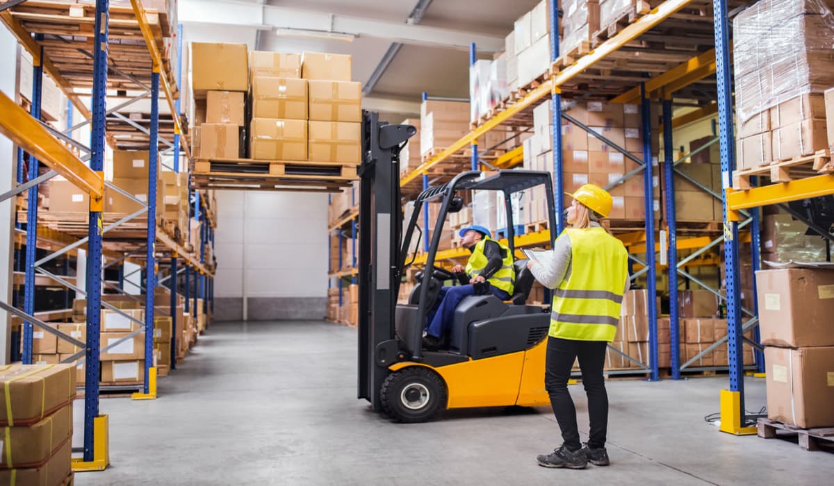 man in heftruck verplaatst dozen