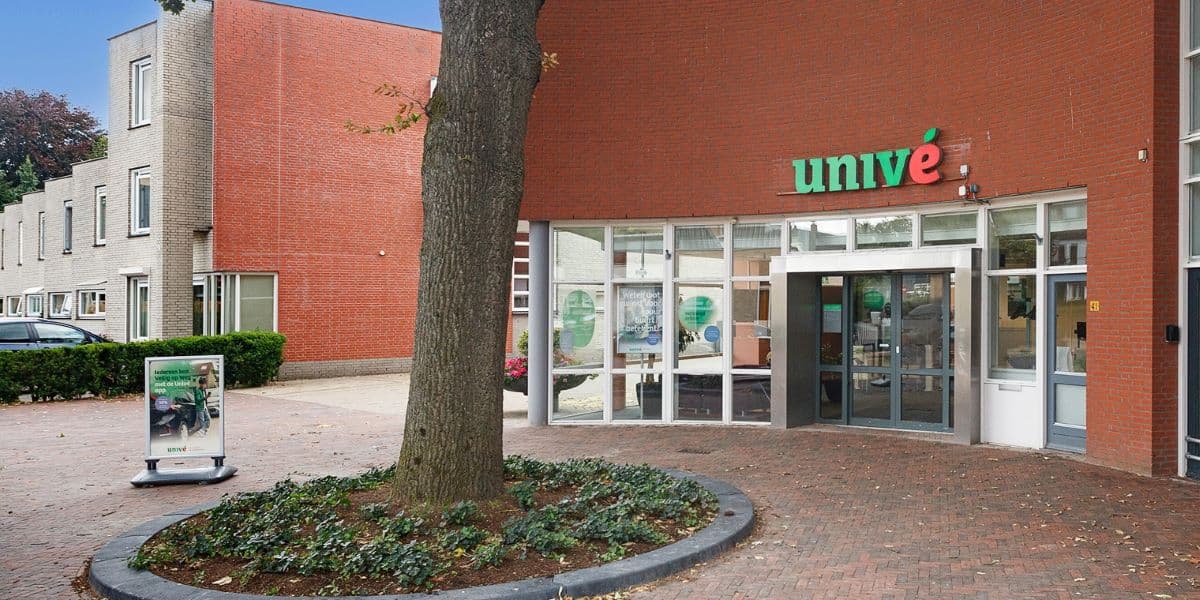 Voorgevel van Univé winkel in Twello met grote boom op de voorgrond