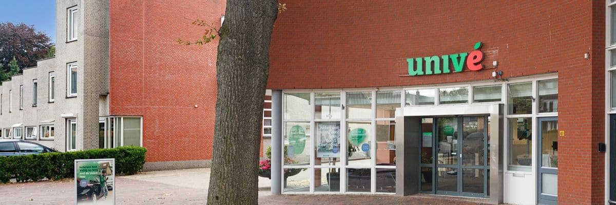 Voorgevel van Univé winkel in Twello met grote boom op de voorgrond