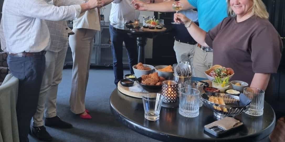 Advema en Unive Zuid-Nederland hebben de samenwerkingsovereenkomst getekend en heffen het glas. Van links naar rechts, Jacob Valkenburg, Francis en Brigitte (UZN), John Kopmels, Peter Krijgsman, Jan van Oord (deels zichtbaar), Leander Beerman en Rianne Korteweg.