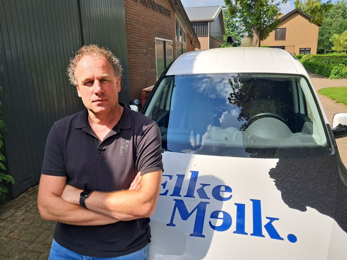 Boer Baan zit op de motorkap van zijn bedrijfsauto met ElkeMelk-logo